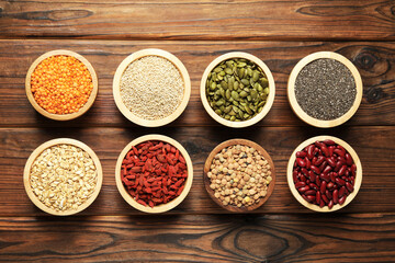 Different superfood products on wooden table, flat lay