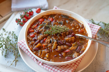 Mediterranean minced meat bean soup with peppers, eggplant, tomatoes and herbs, fresh and homemade cooked on a plate
