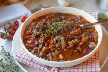 Mediterranean minced meat bean soup with peppers, eggplant, tomatoes and herbs, fresh and homemade cooked on a plate