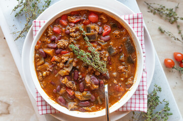 Mediterranean minced meat bean soup with peppers, eggplant, tomatoes and herbs, fresh and homemade cooked on a plate