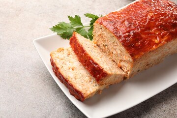 Delicious baked turkey meatloaf with parsley on grey table, closeup