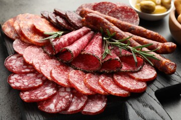 Different smoked sausages slices served on grey table, closeup