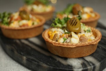 Tartlets with delicious filling on table, closeup