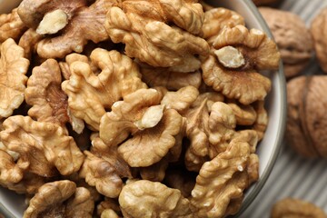 Fresh walnuts in bowl on table, top view