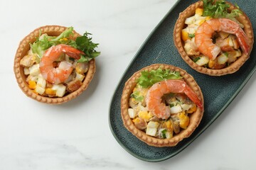 Tartlets with delicious filling on white marble table, flat lay