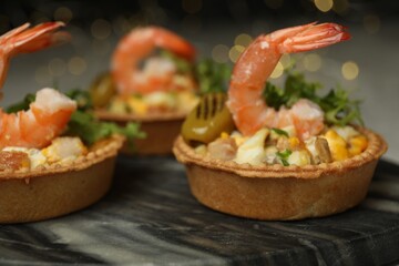 Tartlets with delicious filling on table, closeup. Bokeh effect