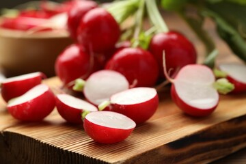 Fresh cut radishes on wooden board, closeup