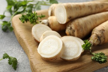 Parsley roots and leaves on grey table, closeup