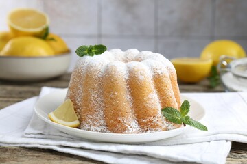 Tasty lemon cake with powdered sugar on wooden table, closeup