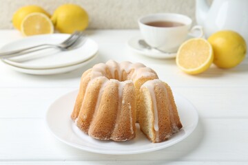 Delicious lemon cake with glaze on white wooden table, closeup