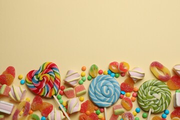 Many different tasty candies and marshmallows on beige background, flat lay. Space for text