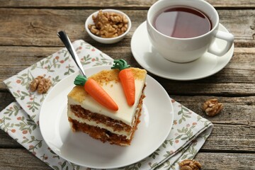 Piece of delicious homemade carrot cake served on wooden table