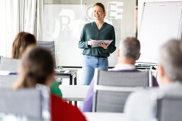 Smiling mentor teaching strategies at education training class in office