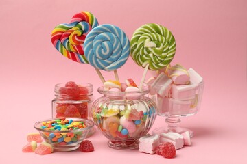 Many different tasty candies on pink background