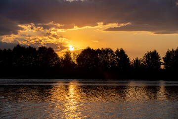Obraz premium river at sunset, the colorful sky and clouds are reflected on the river