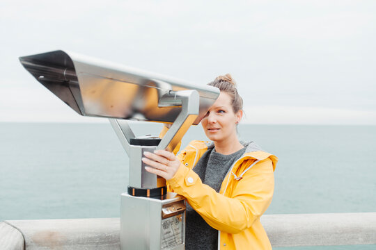 Young blond woman looking through telescope