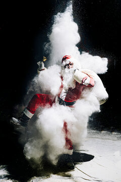 Santa Claus with exploding snow bomb against black background