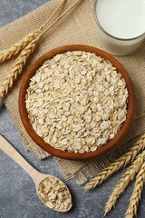 Composition with oatmeal flakes on gray background. Cooking breakfast