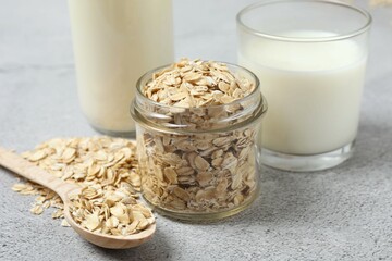 Composition with oatmeal flakes on gray background. Cooking breakfast