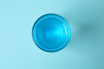 Transparent glass with water on blue background. Drinking clear water in the morning for health