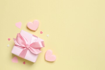 Beautiful gift box with pink hearts on color background