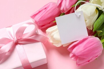 Beautiful fresh tulips with gift box and paper card on color background