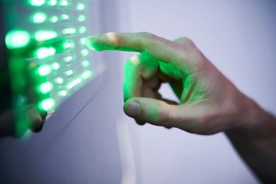 Detail of finger touching green led touchscreen