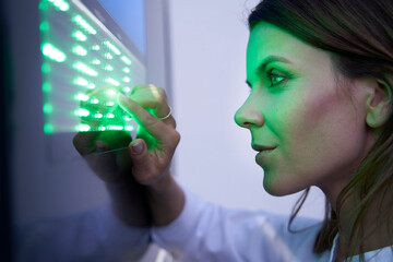 Close-up of woman touching green led touchscreen