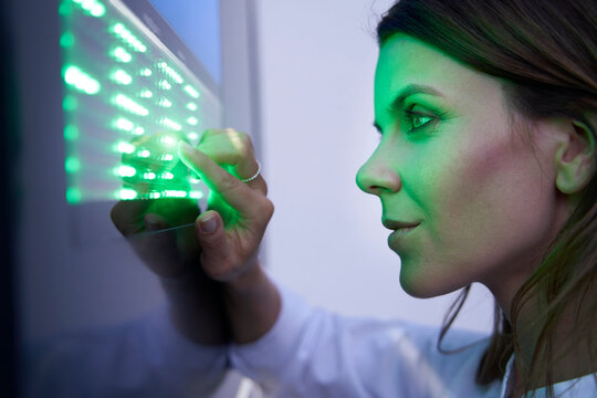 Close-up of woman touching green led touchscreen