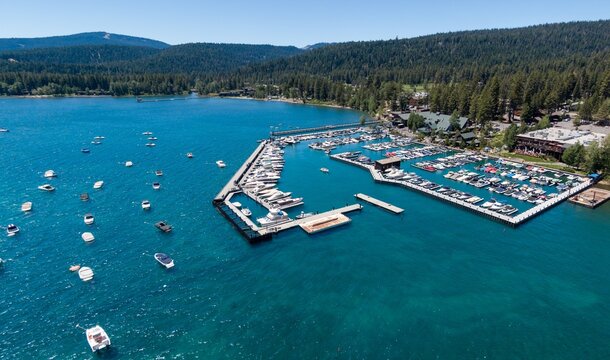 Aerial view of a bustling Lake Tahoe marina. Many boats are docked, and the surrounding area has shops and restaurants. Perfect for a vacation destination. Tahoe City,  California, USA