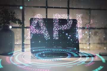 API technology concept with holographic elements on a laptop screen in a modern office environment.