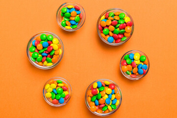 different colored round candy in bowl and jars. Top view of large variety sweets and candies with copy space