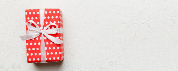 Valentine day composition: red gift box with bow and heart. Christmas present. View from above. Space for text. Holday greeting card