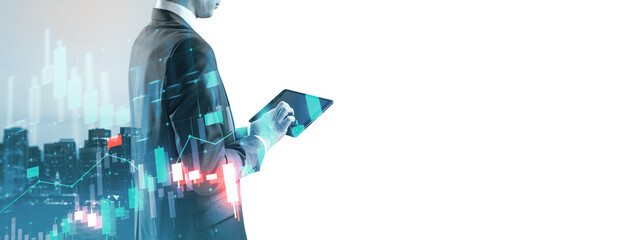 Businessman using tablet with stock market graph overlay.