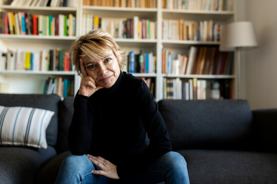 Portrait of mature woman sitting on couch at home