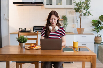 Lifestyle people, using computer working online, doing searching,  sitting in the kitchen.