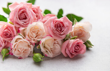 Delicate pink and peach roses forming a beautiful bouquet on a textured surface
