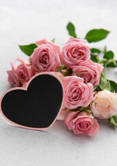 Pink roses bouquet with heart shaped blackboard sign celebrating love and romance