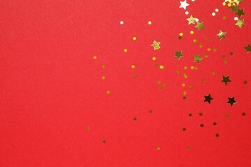 Golden confetti on color background, top view