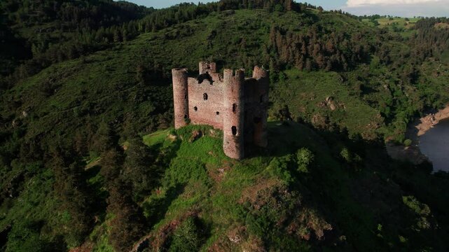 aerial shot revealing Alleuze Castle and landscapce at sunset on a sunny day, Cantal department, Auvergne Rhone Alpes region, France