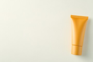 Bright orange tube against minimalist backdrop highlights skinca