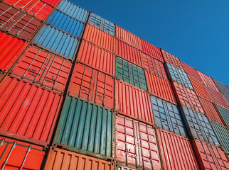 Low angle view of cargo containers against blue sky