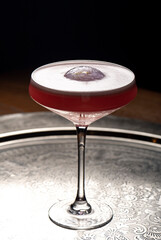 Cocktail in a martini glass on a dark background.