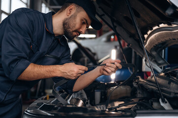 Cable installation. Mechanic working in a car service station