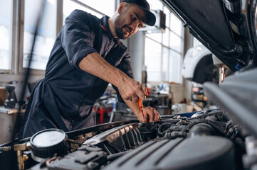 In the cap, busy. Mechanic working in a car service station
