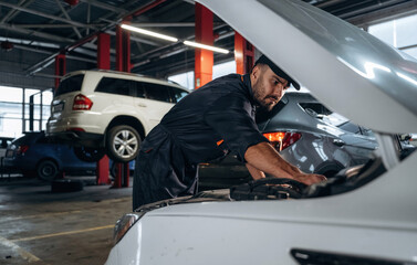 Transport is being repaired. Mechanic working in a car service station