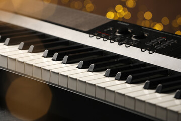 Piano against blurred lights, closeup. Bokeh effect