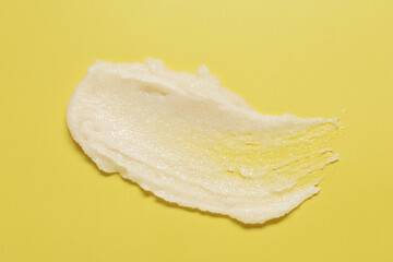 Sample of body scrub on yellow background, top view