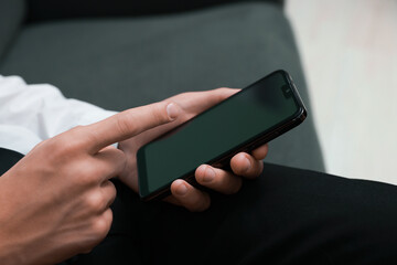Man using smartphone with blank screen indoors, closeup