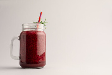 Fresh beetroot smoothie in mason jar on light grey background. Space for text